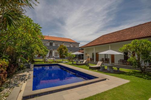a backyard with a swimming pool and a house at The Uma Canggu in Canggu