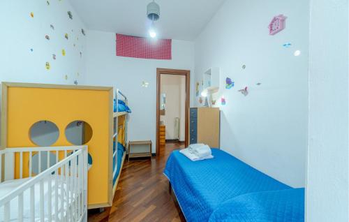 a childs bedroom with a crib and a blue bed at 2 Bedroom Lovely Apartment In Le Grazie in Le Grazie