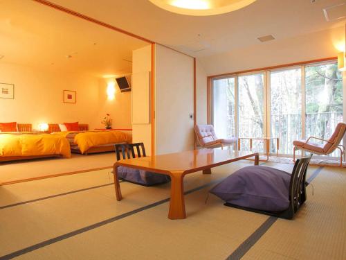 a bedroom with a bed and a table and chairs at Notoya in Komatsu