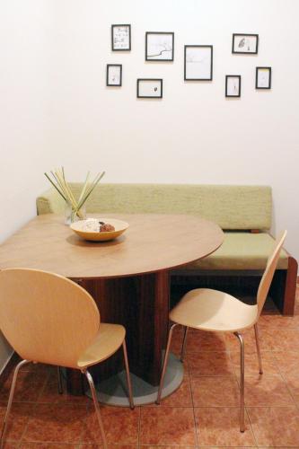 a table and two chairs and a couch with pictures on the wall at Horn Gästehaus in Leinfelden-Echterdingen