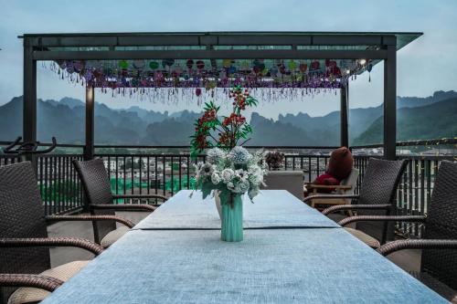 a vase of flowers on a table on a deck at 一树一花客栈眷恋店 in Hanqiyu