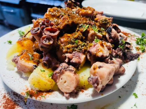 a plate of food with meat and potatoes on a table at Hotel brisas del mar 2022 in Catia La Mar