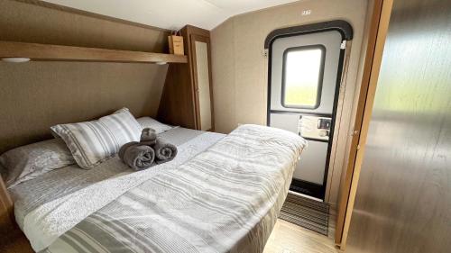 een kleine slaapkamer met een bed met handdoeken erop bij 63 Acre Farmstay - A luxury farm experience in San Mateo