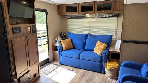 een woonkamer met een blauwe bank in een camper bij 63 Acre Farmstay - A luxury farm experience in San Mateo
