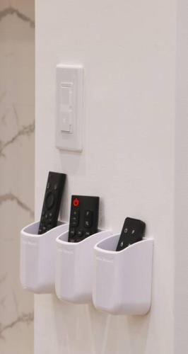 three remote controls in white holders on a wall at Espectacular y Moderno Apartamento Paradise a 15 min en vehiculo del Zocalo de Oaxaca in Oaxaca City