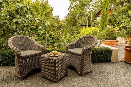 two wicker chairs and a table on a patio at Nestled amongst nature in Havelock North in Havelock North