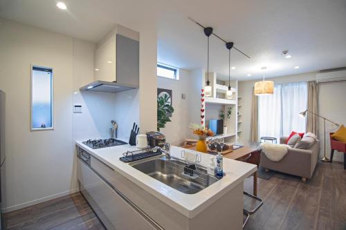 a kitchen with a sink and a living room at -旅time 小路東- Koji Higashi 車庫付き戸建 4LDK in Osaka