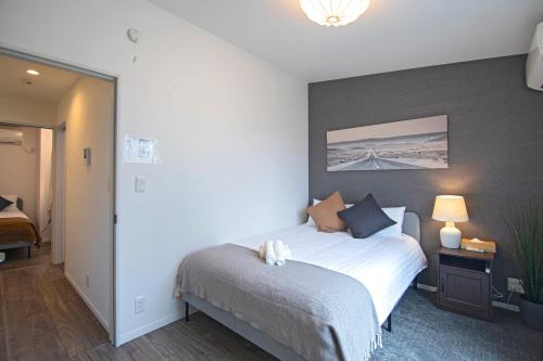 a bedroom with a bed in a room with a wall at -旅time 小路東- Koji Higashi 車庫付き戸建 4LDK in Osaka