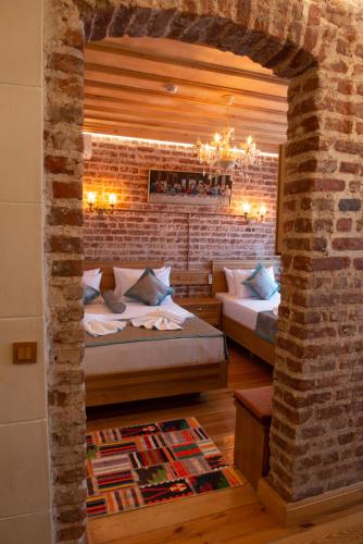 a bedroom with two beds and a brick wall at İstanbul Eagle's Nest Boutique Hotel in Istanbul