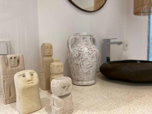 a group of wooden statues and a vase on a counter at Villa Mei, 2BR Pool, Seseh Beach in Dalung