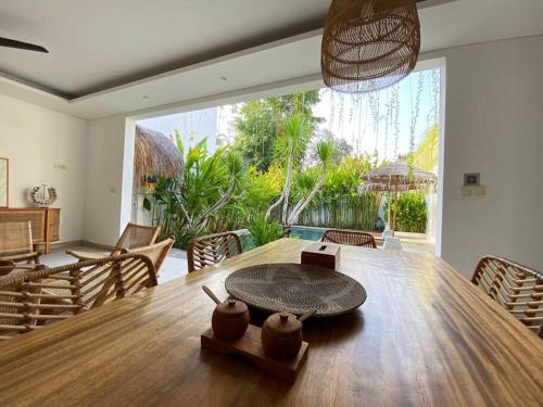 a dining room with a table and a large window at Villa Mei, 2BR Pool, Seseh Beach in Dalung
