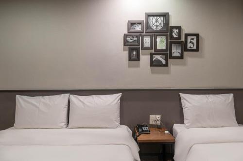 two beds in a room with pictures on the wall at No 25 Hotel Gwangan in Busan