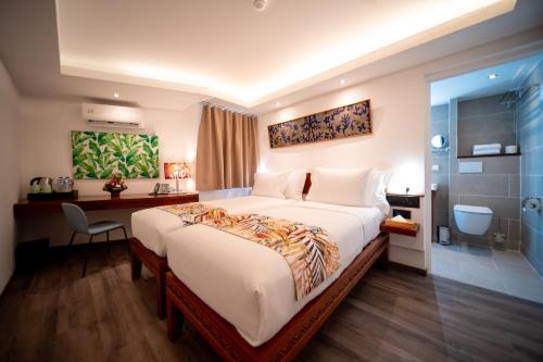 a hotel room with a large bed and a desk at Maitai Express Tahiti in Papeete
