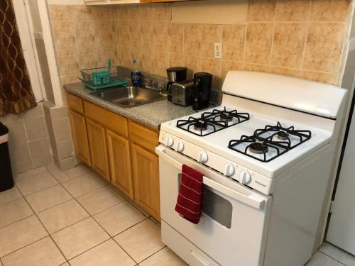 eine Küche mit weißem Herd und Spüle in der Unterkunft Private 1-bedroom apartment only 15 minutes to New York City Manhattan in Union City
