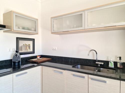 a kitchen with white cabinets and a sink at Villa Marcia Home - Nature, Golf, Beaches-Lagos in Portimão