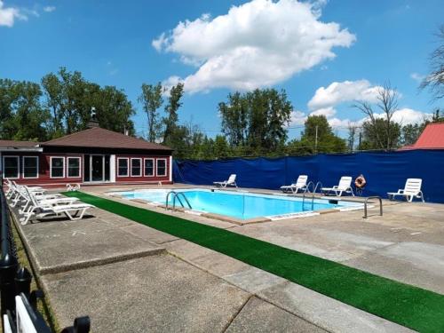 a swimming pool with chairs and a blue fence at Anchor Motel in Niagara Falls