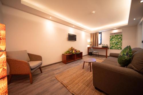 a living room with a couch and chairs and a table at Maitai Express Tahiti in Papeete