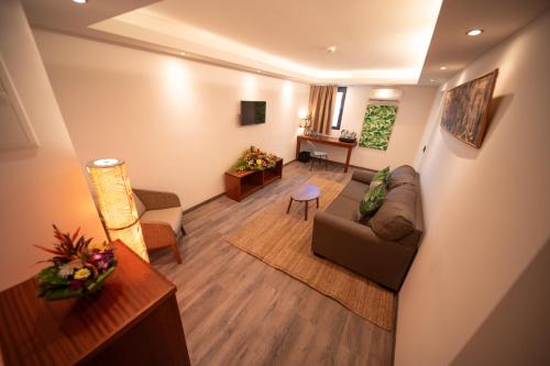 a living room with a couch and a table at Maitai Express Tahiti in Papeete