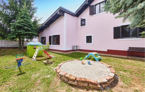 a yard with playground equipment in front of a house at Beautiful Home In Budrovac With Wi-Fi in Budrovac