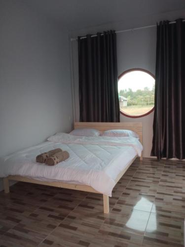 a bed in a bedroom with a large window at จันทร์ทิพย์คคำชะโนด 2 เฟท 2 in Ban Dung