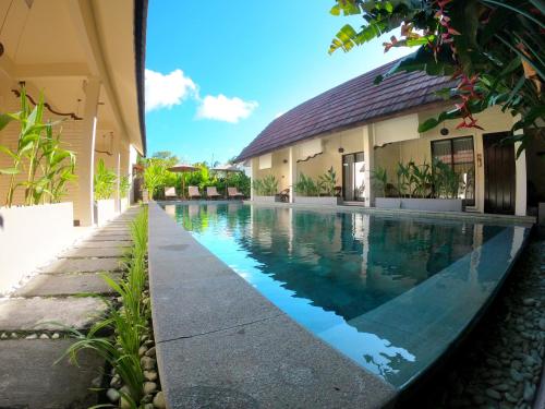 a swimming pool in front of a building at Bruga Villas Restaurant and Spa in Selong Belanak