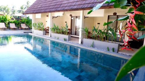 a swimming pool in front of a house at Bruga Villas Restaurant and Spa in Selong Belanak