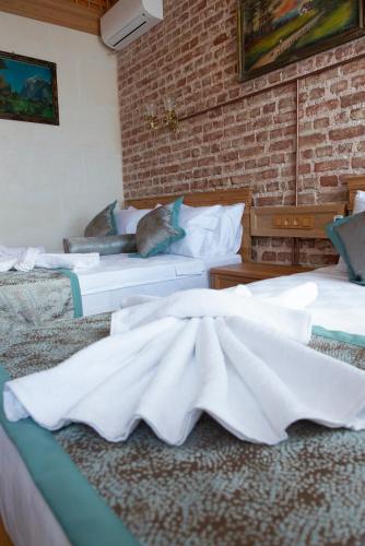 two beds in a room with a brick wall at İstanbul Eagle's Nest Boutique Hotel in Istanbul