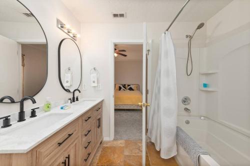 a bathroom with a shower and a sink and a tub at Oasis Rental in Sanford