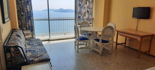 a room with a table and chairs and a view of the ocean at Las Torres Gemelas depto 2310 N in Acapulco