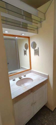 a bathroom with a sink and a mirror at Las Torres Gemelas depto 2310 N in Acapulco