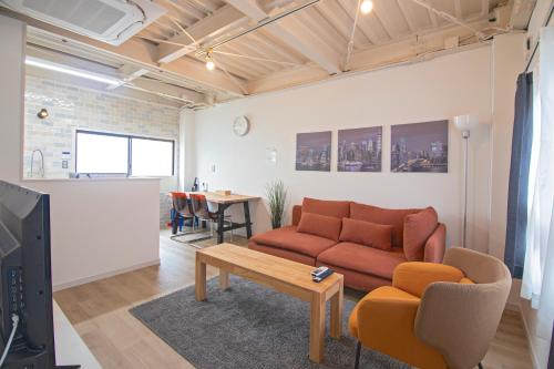 a living room with a couch and a table at 旅タイム・西長堀　駅まで徒歩6分　USJ電車8分 in Osaka