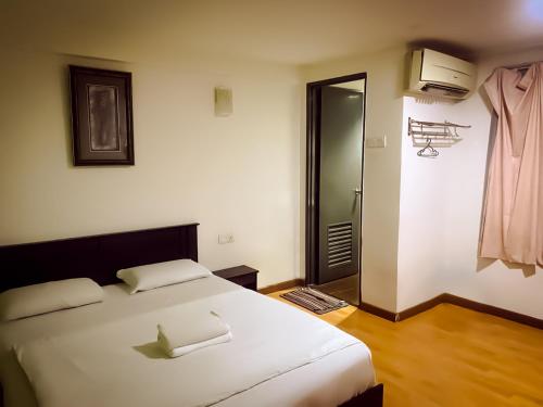 a bedroom with a large white bed and a bathroom at TM Hotel in Kuala Lumpur