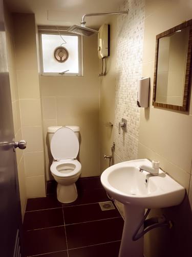 a bathroom with a toilet and a sink at TM Hotel in Kuala Lumpur