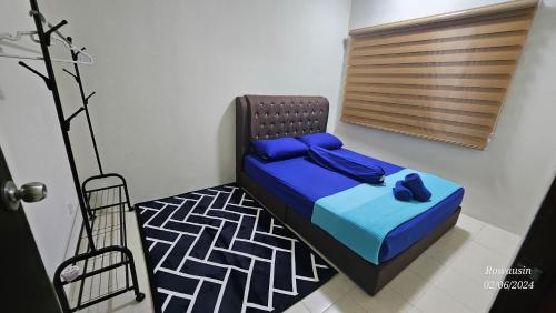 a bedroom with a bed with blue sheets and blue pillows at Ruzarani Home Meru Suria in Chemor
