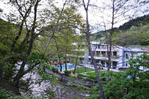 a view of a house and a river with trees at Family Hotel BOHEMA in Ognyanovo
