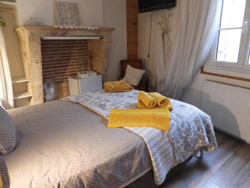 a bedroom with a bed with a yellow towel on it at B&B Le Miroir aux Fées Bordeaux in Bordeaux