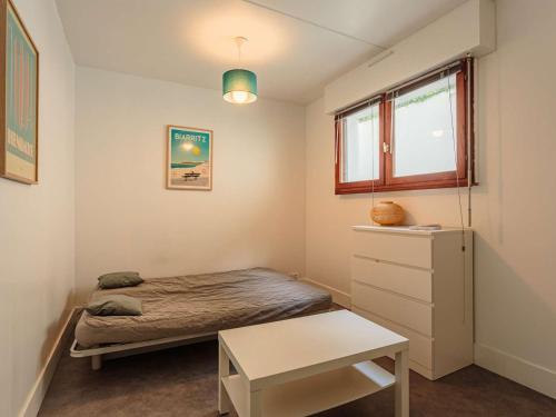 une petite chambre avec un lit et une fenêtre dans l'établissement Studio rénové avec piscine, Wi-Fi, proche centre ville et plage - FR-1-3-610, à Biarritz