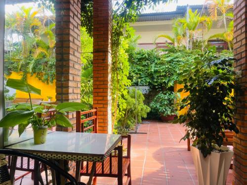 a table and chairs on a patio with plants at Mui Ne Garden Hotel and Kite School in Mui Ne