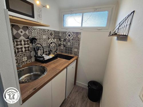 une petite cuisine avec un évier et une fenêtre dans l'établissement Gîte 2 pers. proche plages et Marais Poitevin, terrasse couverte, tout inclus - FR-1-426-551, à Saint-Michel-en-lʼHerm