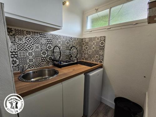 une petite cuisine avec un évier et un comptoir dans l'établissement Gîte cosy entre plages et Marais Poitevin, tout inclus, à 600m du bourg historique de Saint-Michel - FR-1-426-552, à Saint-Michel-en-lʼHerm