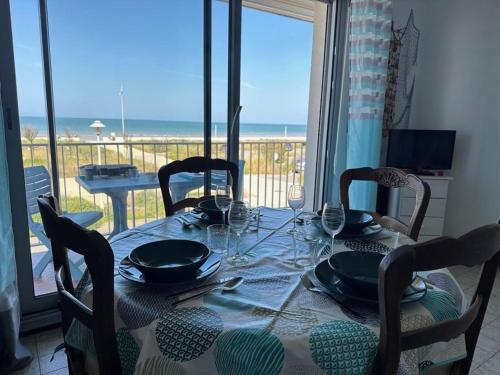 - une table à manger avec des chaises et une table offrant une vue sur l'océan dans l'établissement Studio 26m² - 4 pers - Notre-Dame-de-Monts - Animaux admis, Parking, Balcon - FR-1-540-292, à Notre-Dame-de-Monts