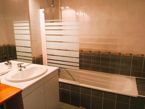 une salle de bain avec un lavabo et une baignoire dans l'établissement Appartement lumineux proche centre et plage avec terrasse et parking, Capbreton - FR-1-239-1056, à Capbreton