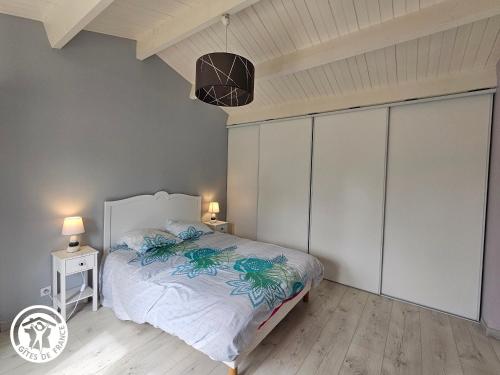 a bedroom with a bed and two night stands and two lamps at Gîte cosy avec piscine près des plages et du Marais Poitevin - FR-1-426-553 in Saint-Michel-en-lʼHerm