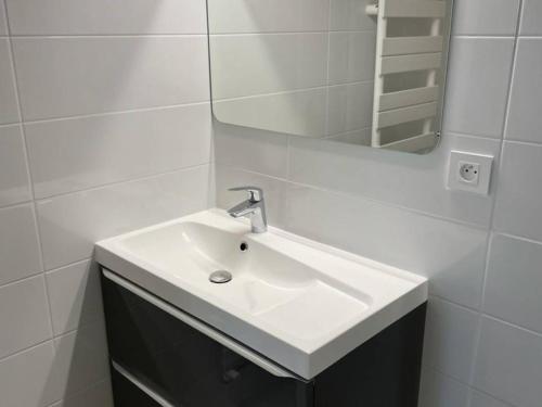 une salle de bain blanche avec un lavabo et un miroir dans l'établissement Marina 3P avec clim, terrasse, quai privatif, proche plage - 6 couchages - FR-1-731-73, au Grau-du-Roi