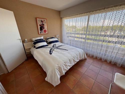 une chambre avec un lit et une grande fenêtre dans l'établissement Appartement 3 Pièces, Piscine Privée, Proche Plage - Port Camargue - FR-1-731-74, au Grau-du-Roi