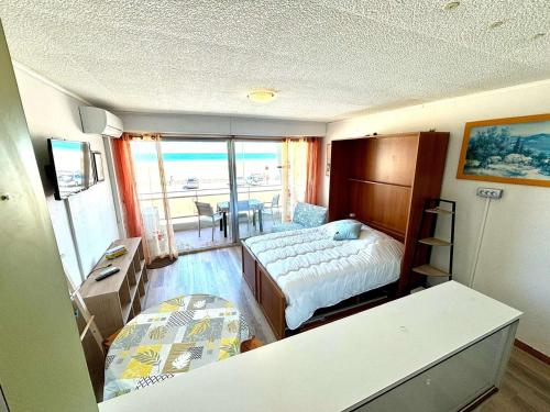 une chambre avec un lit, un bureau et une table dans l'établissement Studio face à la mer, 3 couchages, balcon, parking, à 10m de la plage - Port-la-Nouvelle - FR-1-229C-98, à Port-la-Nouvelle