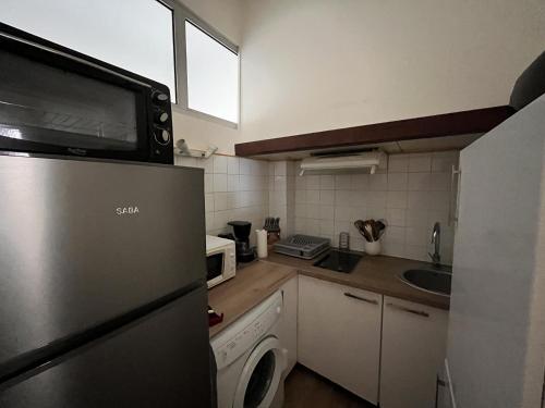 une cuisine avec un réfrigérateur et une machine à laver dans l'établissement Charmant T2 en centre-ville, 1er étage, La Roche-Posay, pour 4 pers, animaux bienvenus - FR-1-541-107, à La Roche-Posay