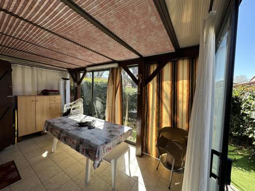 une véranda avec une table et des chaises dans l'établissement Pavillon charmant avec mezzanine, piscine et commodités à proximité - Argelès-sur-Mer - FR-1-732-73, à Argelès-sur-Mer