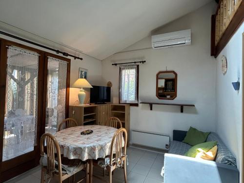 une salle à manger avec une table et un canapé dans l'établissement Pavillon charmant avec mezzanine, piscine et commodités à proximité - Argelès-sur-Mer - FR-1-732-73, à Argelès-sur-Mer
