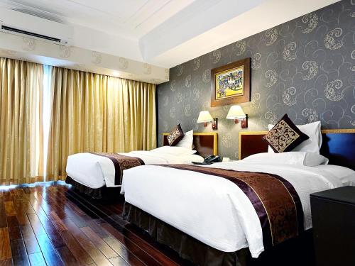 a hotel room with three beds in a room at Rex Hotel in Ho Chi Minh City